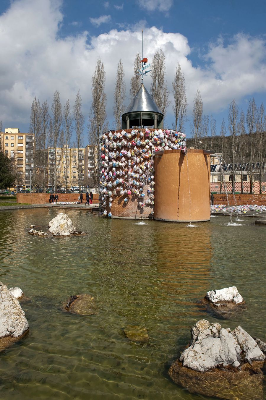 Un centenar de guirnaldas de bolsas de plástico decoran desde hoy jueves la fuente del Parque del Mundo de Pamplona